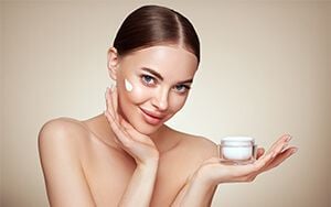 woman applying cream on her face woman applying cream on her face